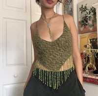 a woman wearing a green top and black pants